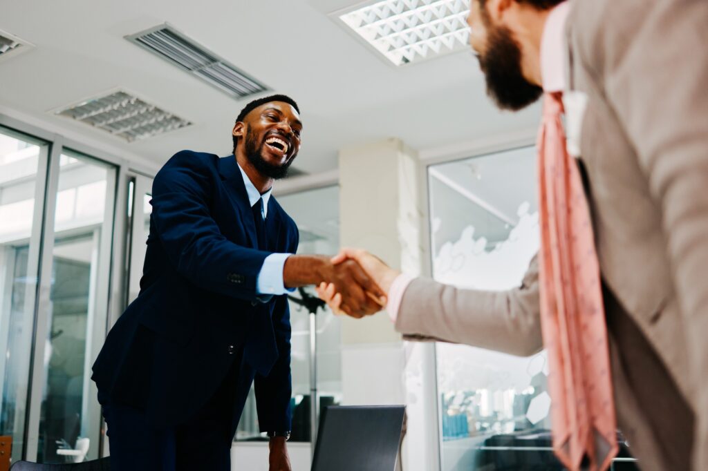 Two businessmen shaking hands after closing a deal in a modern office